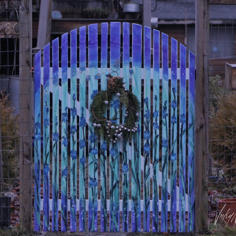 a wooden fence gate painted with blue irises